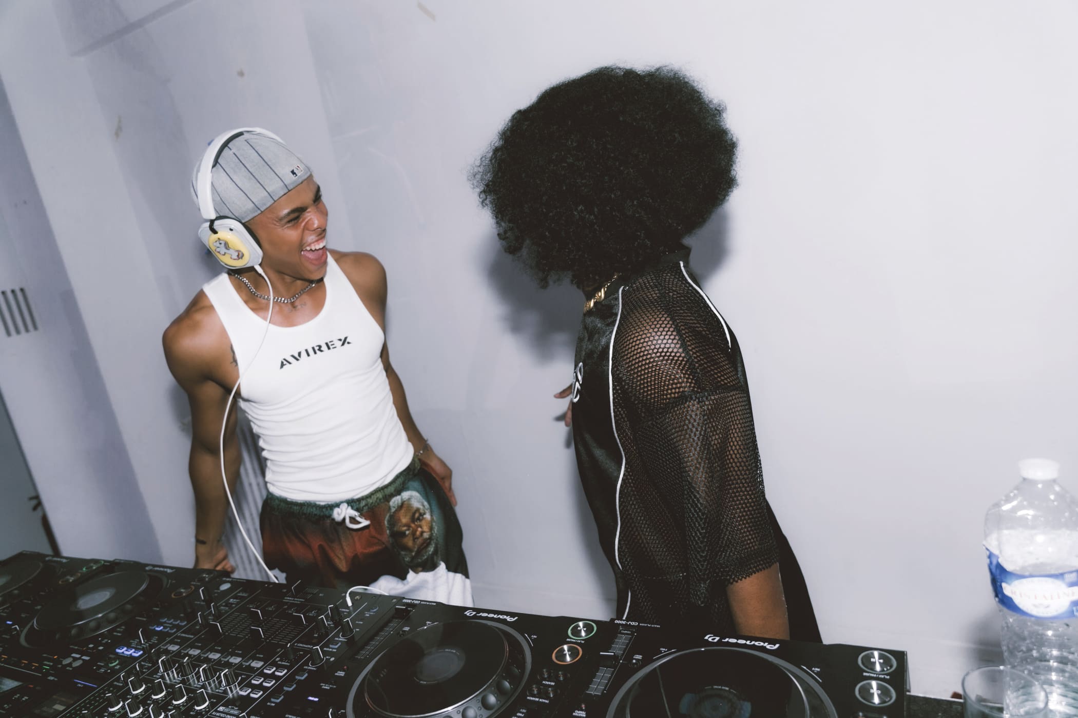 Oluwa laughing across the decks with a performer in black mesh
